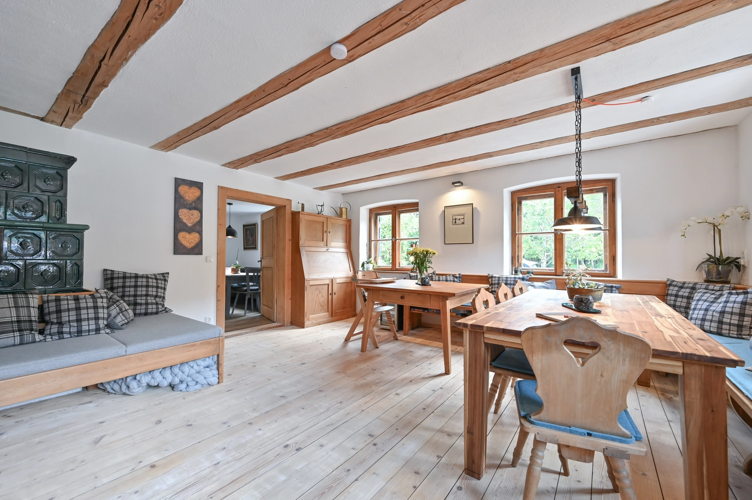 Antjes – Roomstyling –  Nachher:Ein helles, renoviertes Wohn- und Esszimmer mit weiß gestrichenen Wänden, hellem Holzboden, großen Fenstern und modernem Landhaus-Charme.