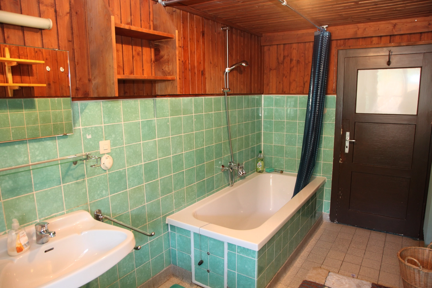 Antjes – Roomstyling –  Vorher: Ein altes Badezimmer mit Holzdecke, mintgrünen Fliesen, einer Badewanne mit Duschvorhang und einfachen Armaturen.